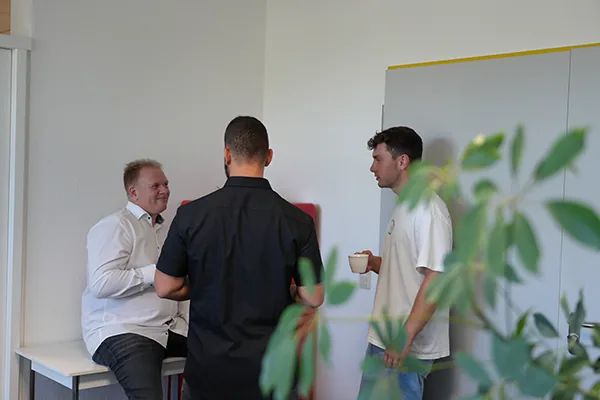 Drei Kollegen im Gespräch in der Büroküche