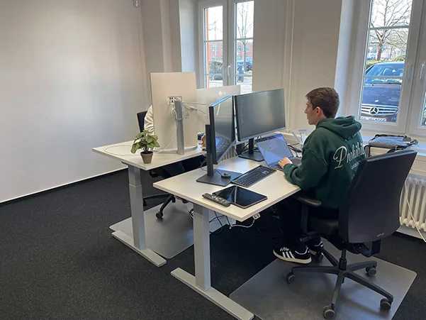 Arbeitsplatz mit höhenverstellbarem Schreibtisch und Doppel-Monitor-Setup